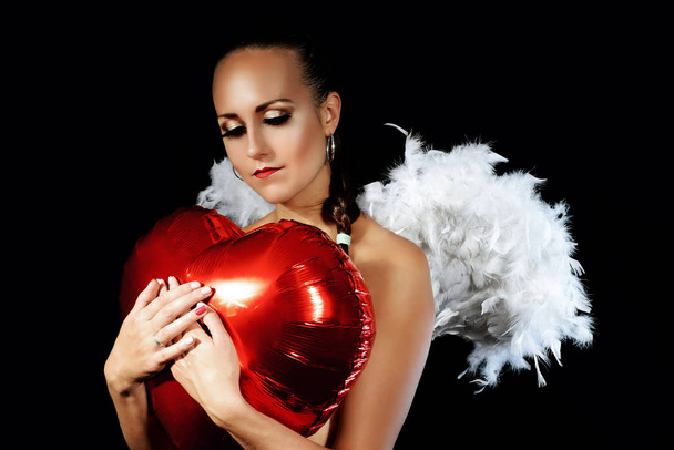 Den svatého Valentýna. Dívka krásná a sexy podprsenky s křídly za zády a balónek ve tvaru srdce. - Fotografie, Obrázek