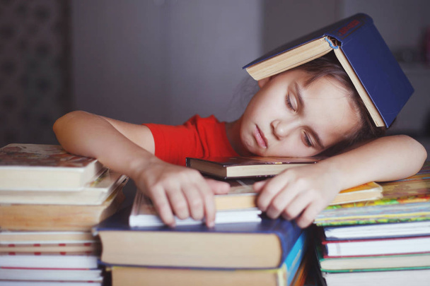 sleeping girl with piles of books - Foto, afbeelding