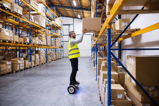 Male warehouse worker on hoverboard. - Photo, Image