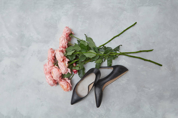 elegant black female shoes and bouquet of pink roses on gray background - Фото, зображення