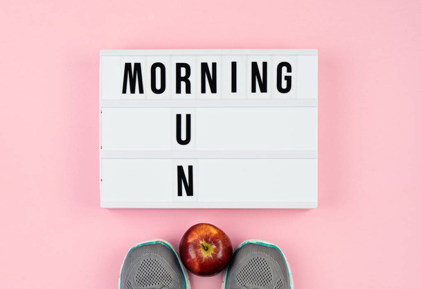 Citas de motivación en la caja de luz, manzana y zapatos deportivos en el rosa
 - Foto, imagen