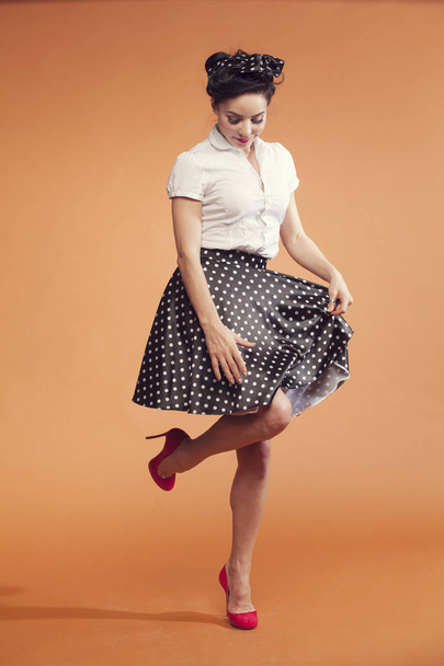young woman in vintage style looks at the skirt - Fotó, kép