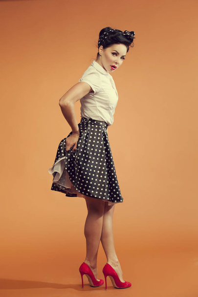 young woman  in vintage style is holding hands in the buttocks  - Photo, Image