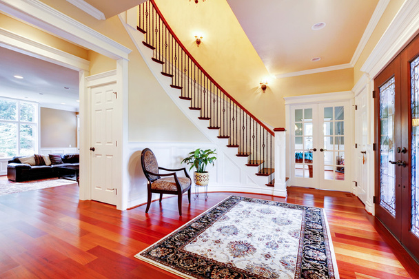 Luxury home entrance with cherry hardwood floor and staircase. - Фото, изображение