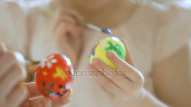 Young mother and her little daughter wearing Bunny ears coloring easter eggs - Filmmaterial, Video