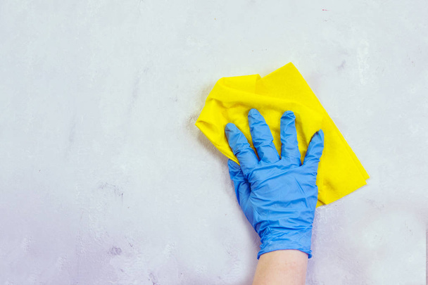 Hand in a household glove washes a rag surface. - Фото, изображение