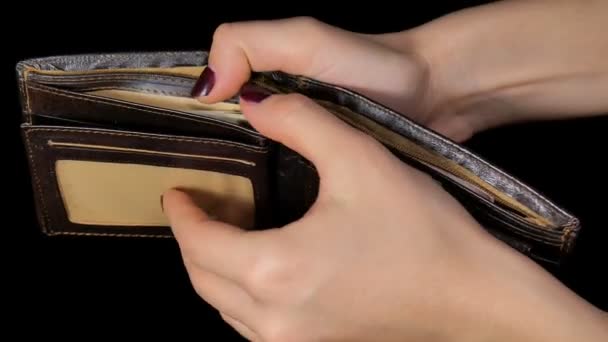 Female hands out cash dollars from purse. Dollar and hryvnia. Black background. - Footage, Video