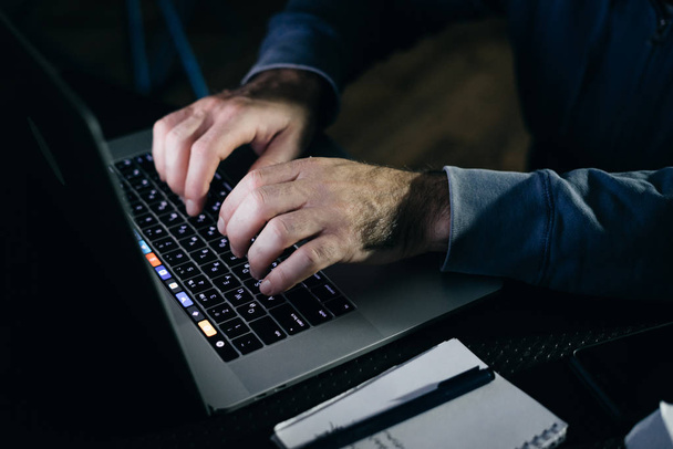 a man hacker is typing something on the keyboard - Foto, Imagen