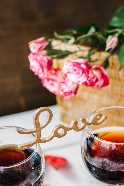 Wooden word LOVE standing on glasses of wine. - Valokuva, kuva