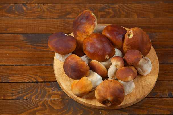  porcini mushrooms on plate on  wooden table - Photo, Image