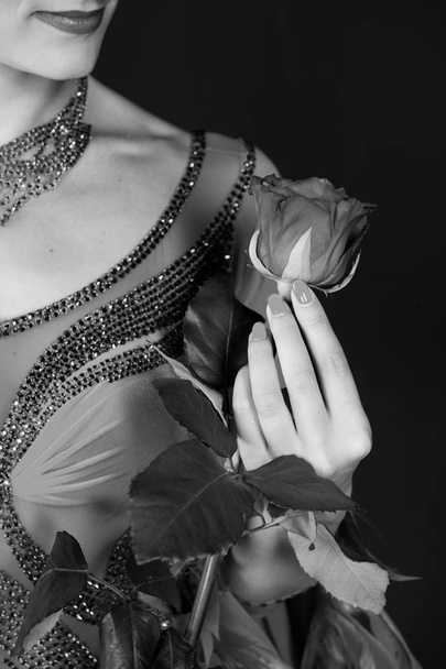 Valentine present, gift, surprise. Rose flower in female hand in dress on dark background. Love, desire, passion. Valentines day, birthday, holiday celebration, black and white - Zdjęcie, obraz