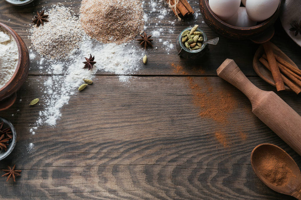 Ingredients for cooking bread or cookies: oat bran, flour, eggs, spices on rustic wooden background. Healthy food concept. Food background. Flat lay with copy space for text - Zdjęcie, obraz