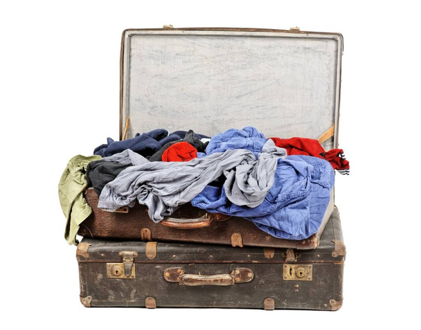 Régi bőrönd, tele ruhák elszigetelt fehér background - Fotó, kép