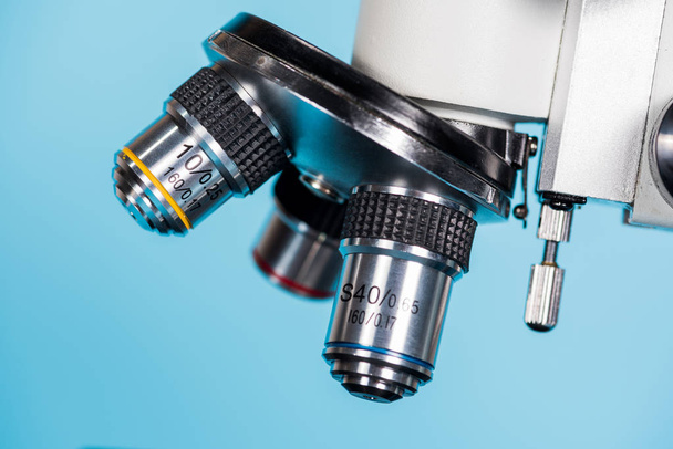 close up of microscope len on light blue background - Photo, Image