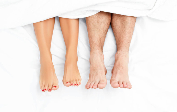 Close up of the feet of a couple on the bed. - Foto, Bild