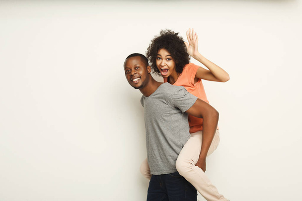Coppia amorevole, uomo piggybacking fidanzata su sfondo bianco
 - Foto, immagini