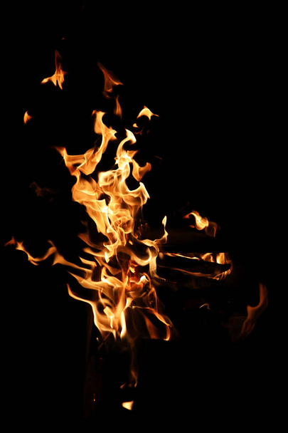 Γλώσσες της φλόγας της φωτιάς του πορτοκαλί-κίτρινο χρώμα από την καύση ελάτης - Φωτογραφία, εικόνα