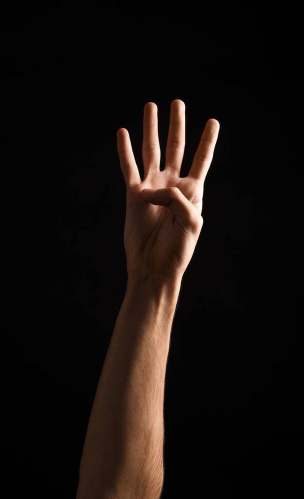 Male hand shows number four isolated at black - Photo, Image