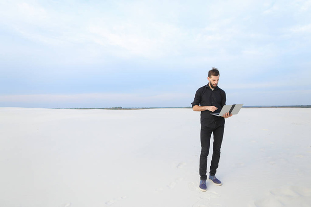 escritor varón con portátil buscar inspiración en la playa
. - Foto, imagen