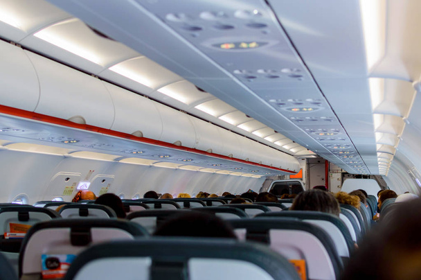 Innenraum des Flugzeugs mit Passagieren auf Sitzen, die auf den Start warten - Foto, Bild