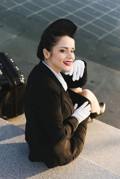 woman stewardess in uniform sits on the steps - Photo, image
