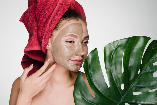 woman with a towel on her head apply a cleansing mask on her face - Foto, Imagem