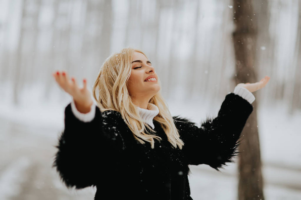 Портрет блондинки на улице в снежном зимнем пальто
 - Фото, изображение
