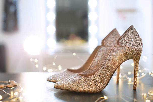 Beautiful high heeled shoes on table with fairy lights - Fotoğraf, Görsel