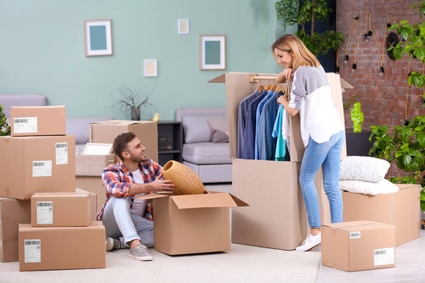 Young couple packing wardrobe boxes on moving day - Фото, зображення