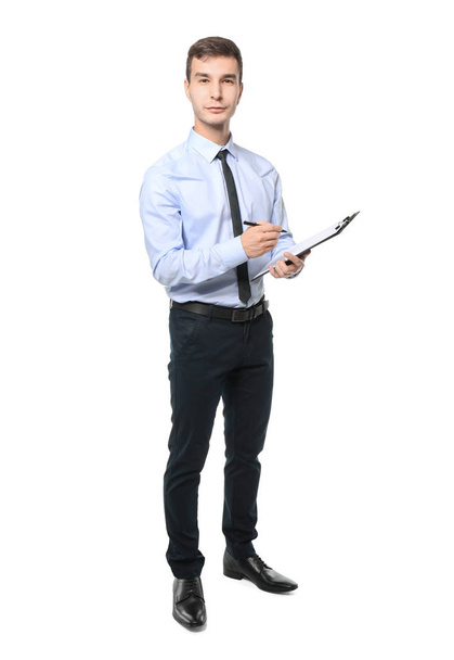 Handsome car salesman writing on clipboard against white background - Foto, afbeelding