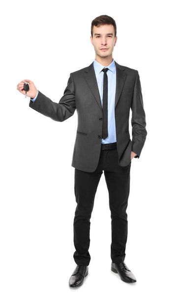 Handsome car salesman with key on white background - Photo, image