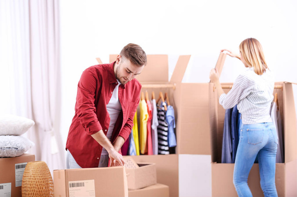 Young couple packing wardrobe boxes on moving day - Foto, Bild
