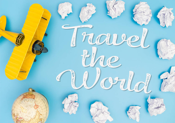 Подорожуйте концепцією світового плаката з жовтим іграшковим літаком на паперовому хмарному небі
 - Фото, зображення