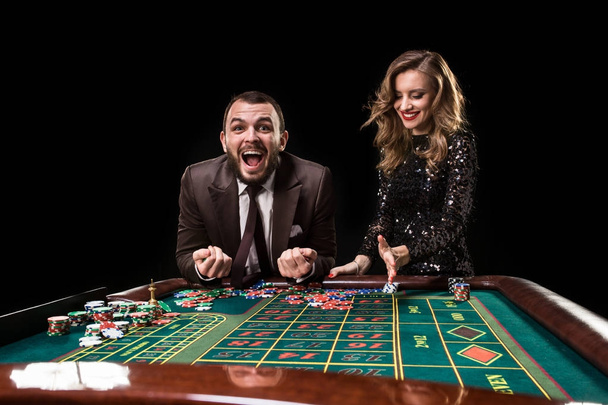 Man with woman playing roulette at the casino. Addiction to the - Fotó, kép