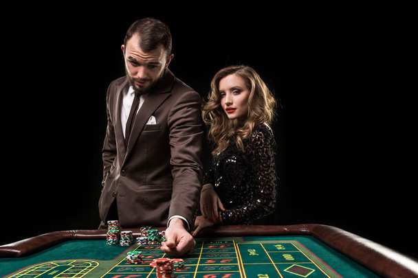 Mężczyzna z kobietą, grając w ruletkę w kasynie. Uzależnienie od - Zdjęcie, obraz