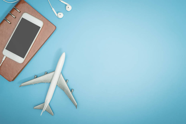 Speelgoed vliegtuig en mobiele telefoon op blauwe exemplaar ruimte voor reizen concept poster en banner - Foto, afbeelding