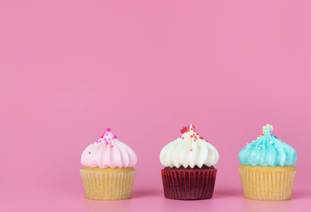 Pembe kopya alan arka plan üzerinde üç mini süslü cupcake - Fotoğraf, Görsel