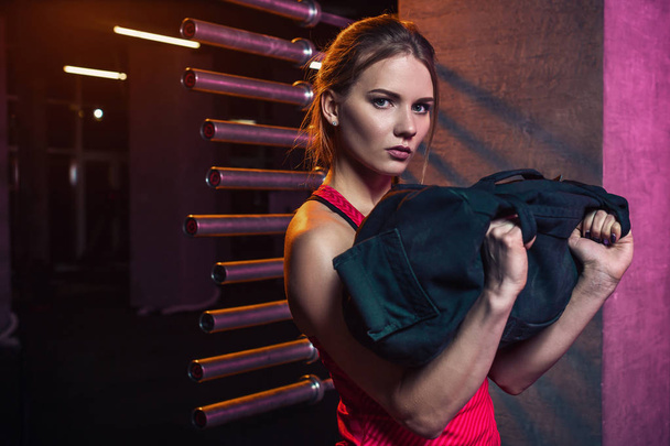 junge schöne Frau posiert in einem Fitnessstudio-Outfit. - Foto, Bild