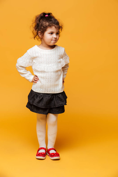 Pretty girl child standing isolated over yellow - Fotografie, Obrázek