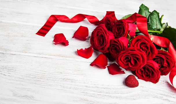 Κόκκινα τριαντάφυλλα σε έναν πίνακα - Φωτογραφία, εικόνα