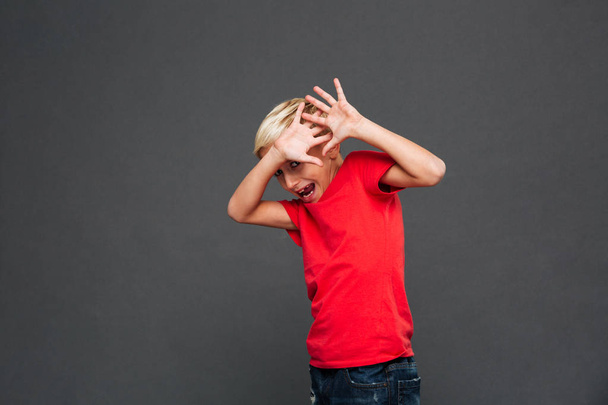 Image of screaming scared little boy child standing isolated over grey background. Looking camera. - Foto, Bild