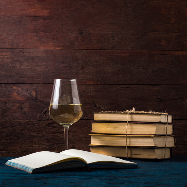 Bücher verbunden durch jgut Seil, Glas mit Weißwein und offenes Buch - Foto, Bild