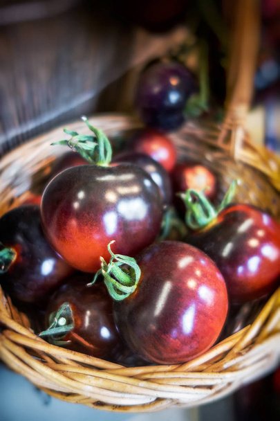 Basket with organic brown kumato tomatoes at the kitchen - Foto, Imagen