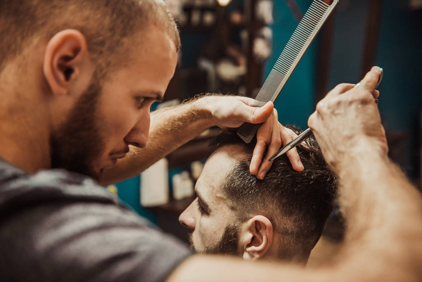 Mężczyzna odwiedza salon fryzjerski. Fryzjerka ma fryzurę do człowieka. Hipster w fryzjera - Zdjęcie, obraz