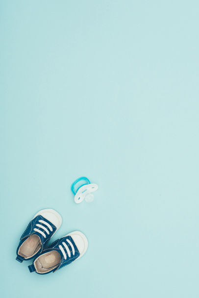 vista superior de zapatos de bebé y maniquí aislado en azul
 - Foto, Imagen