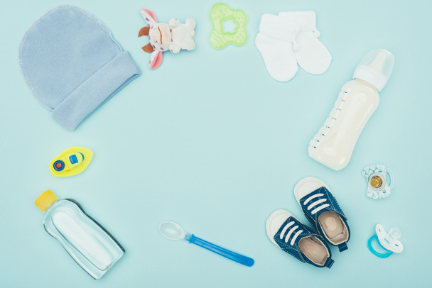 το Top view μωρό ρούχα, αξεσουάρ και γάλακτος απομονωμένη σε μπλε - Φωτογραφία, εικόνα