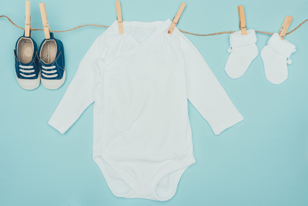 vista superior de la ropa de bebé secado en la cuerda aislada en azul
 - Foto, imagen