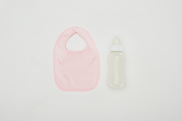 pohled shora baby bib a láhev mléka izolované na bílém - Fotografie, Obrázek