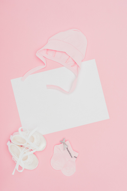 bovenaanzicht van leeg bord met de kleren van de baby geïsoleerd op roze - Foto, afbeelding