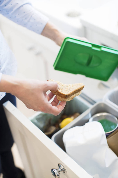Close Of Woman Putting Food Waste Into Recycling Bin In Kitchen - Foto, immagini